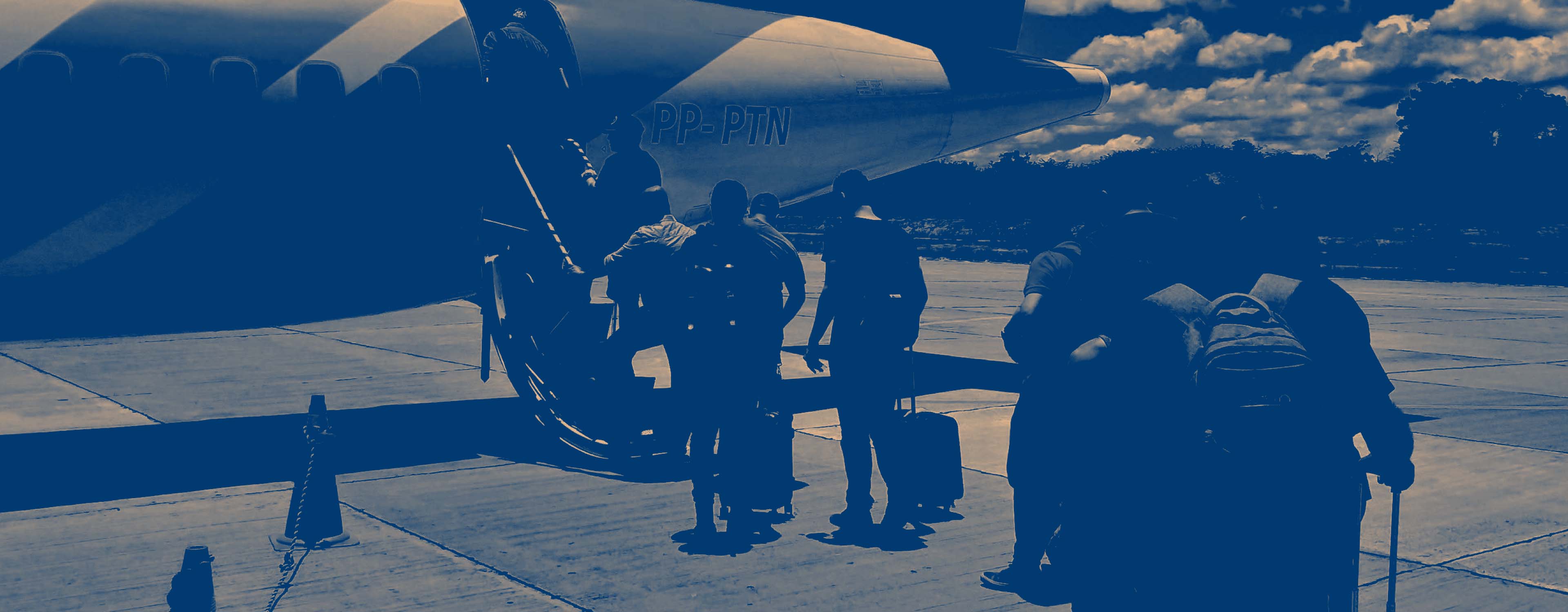 A dark blue and beige duotone of people boarding the rear a plane on foot from the tarmac.