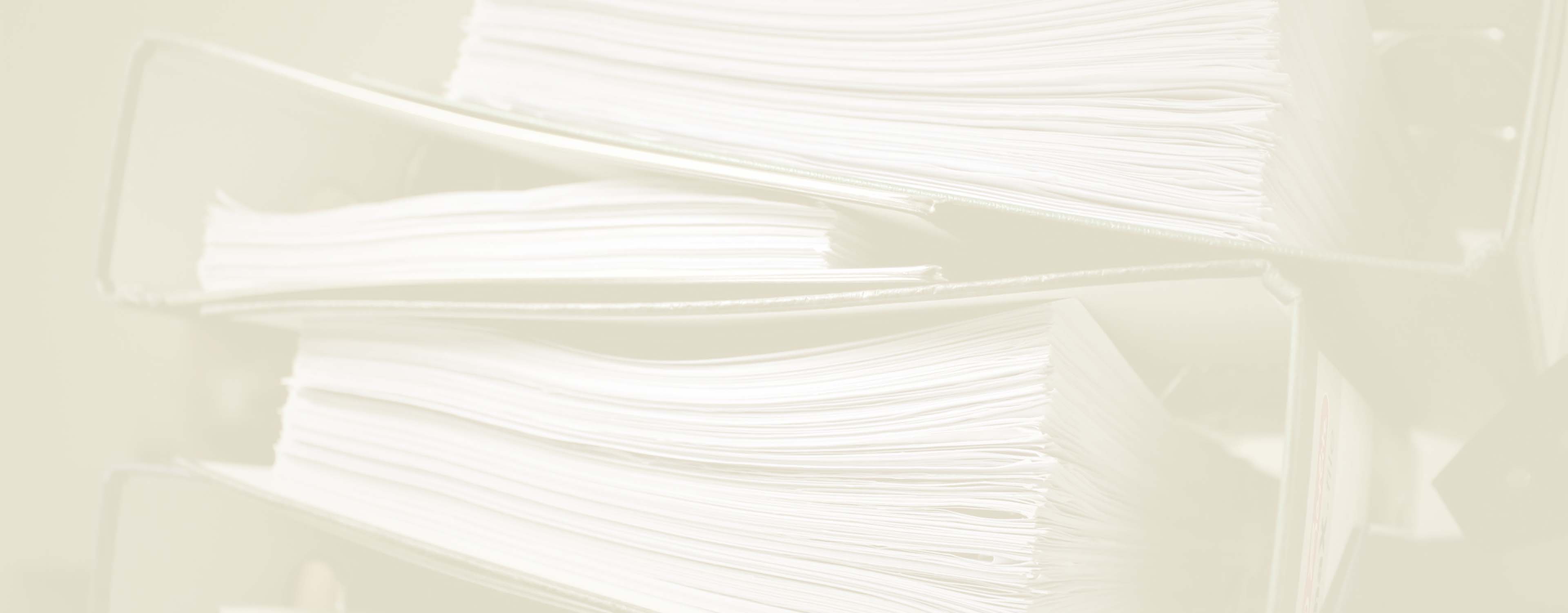 A beige duotone of stacked binders of files. This is seen edge on and close up.